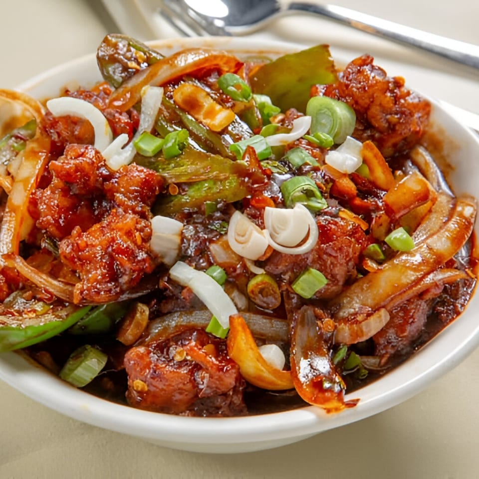 Nanking Indian Restaurant's chili chicken, a vibrant dish with chicken, peppers, and onions in a rich sauce.