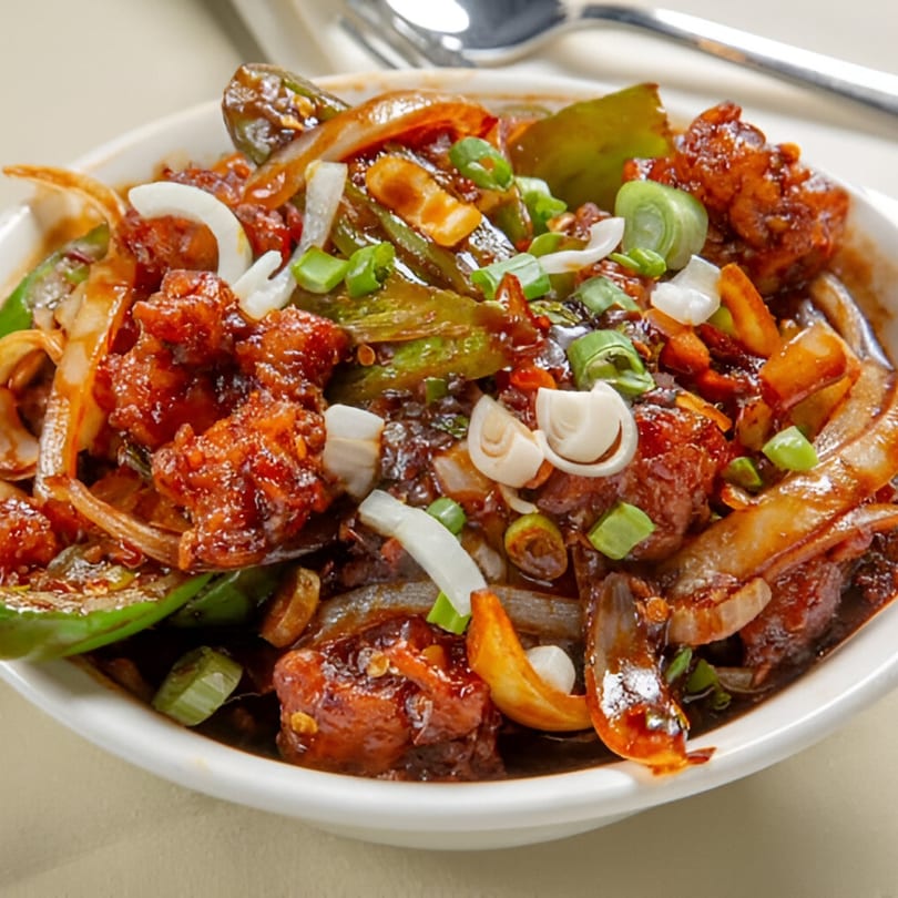 Nanking Indian Restaurant's chili chicken, featuring crispy chicken, onions, and green peppers in a rich sauce.