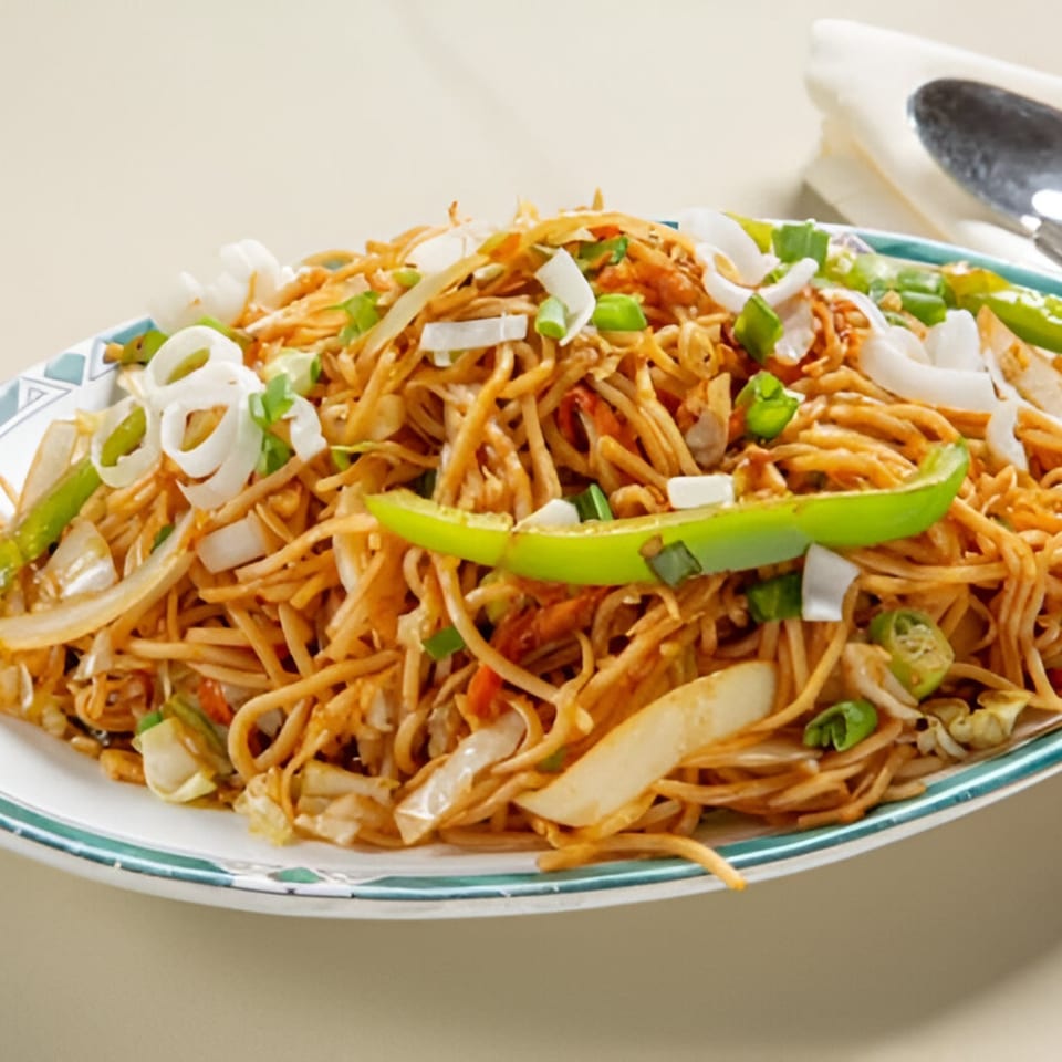 Nanking Indian Restaurant's Hakka Noodles, a plate of stir-fried noodles with vegetables and green chilies.